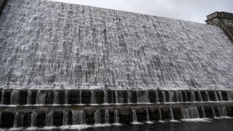 water cascades over the weir at fernworthy reservoir dam in dartmoor national park, devon, england