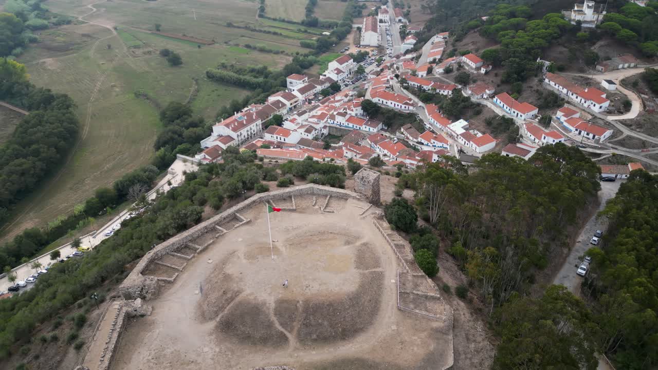 Aerial orbits hilltop stone ruin of Castle of Aljezur in Portugal
