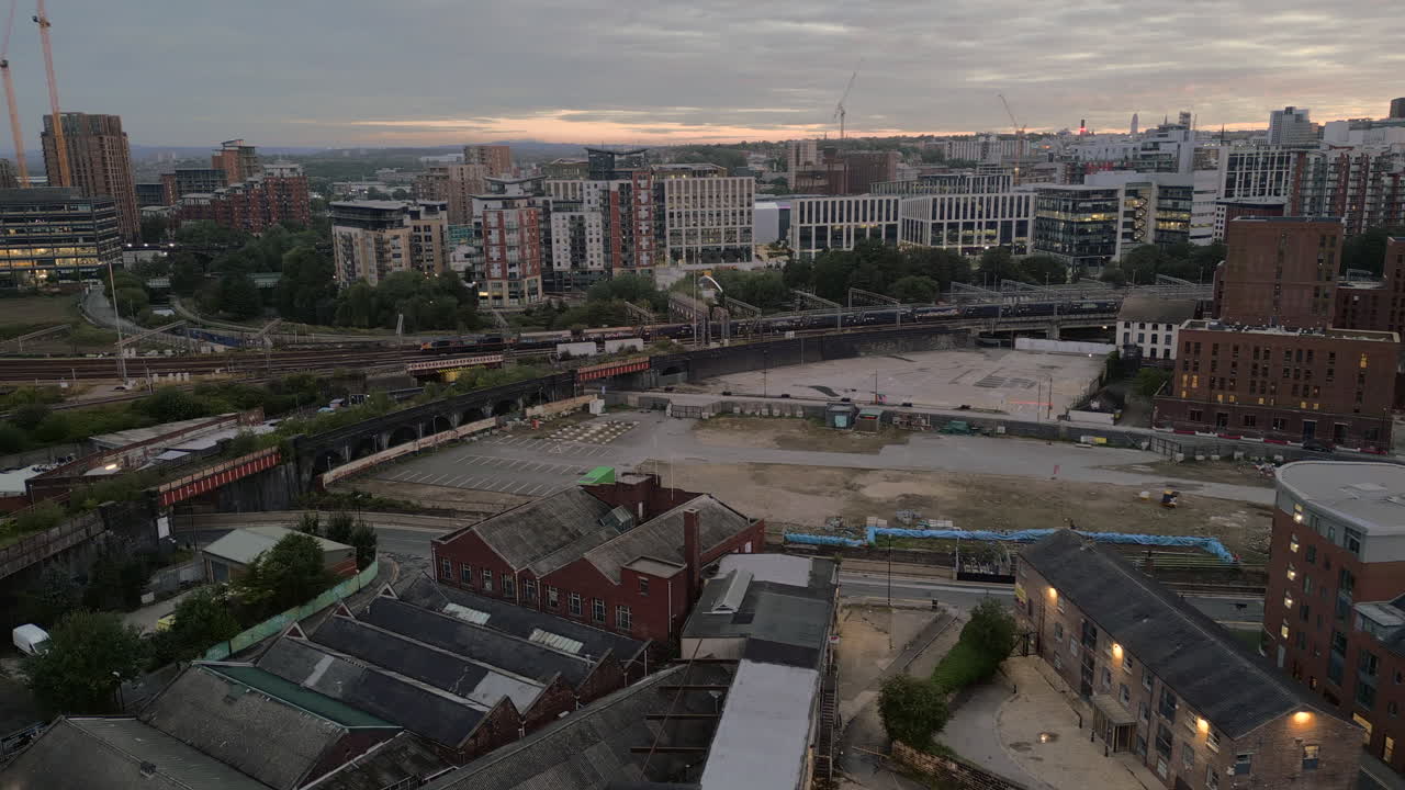 Establishing Aerial Drone Shot of Freight Train Leaving Leeds Train Station with Leeds City Centre in Background art Sunrise