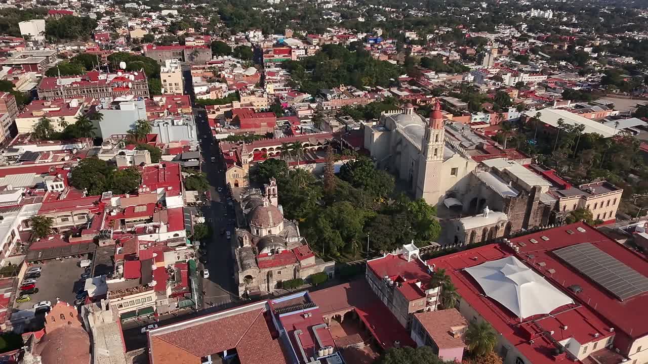 Cuernavaca city center, featuring Catedral de Cuernavaca and a park. Backward ascending shot reveals cityscape