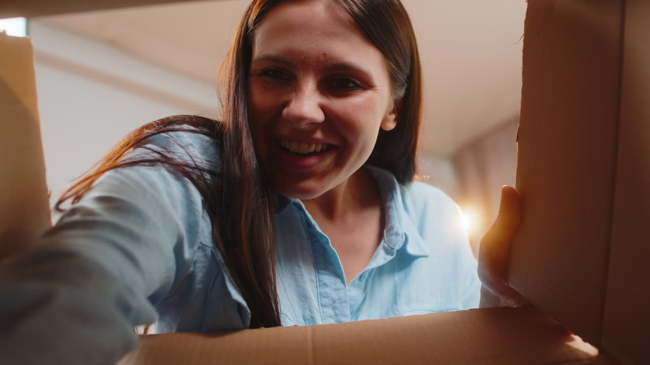 Happy caucasian woman girl shopper unpacking cardboard box delivery parcel online shopping purchase