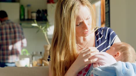 front view of mid adult caucasian mother consoling her baby in a comfortable home 4k