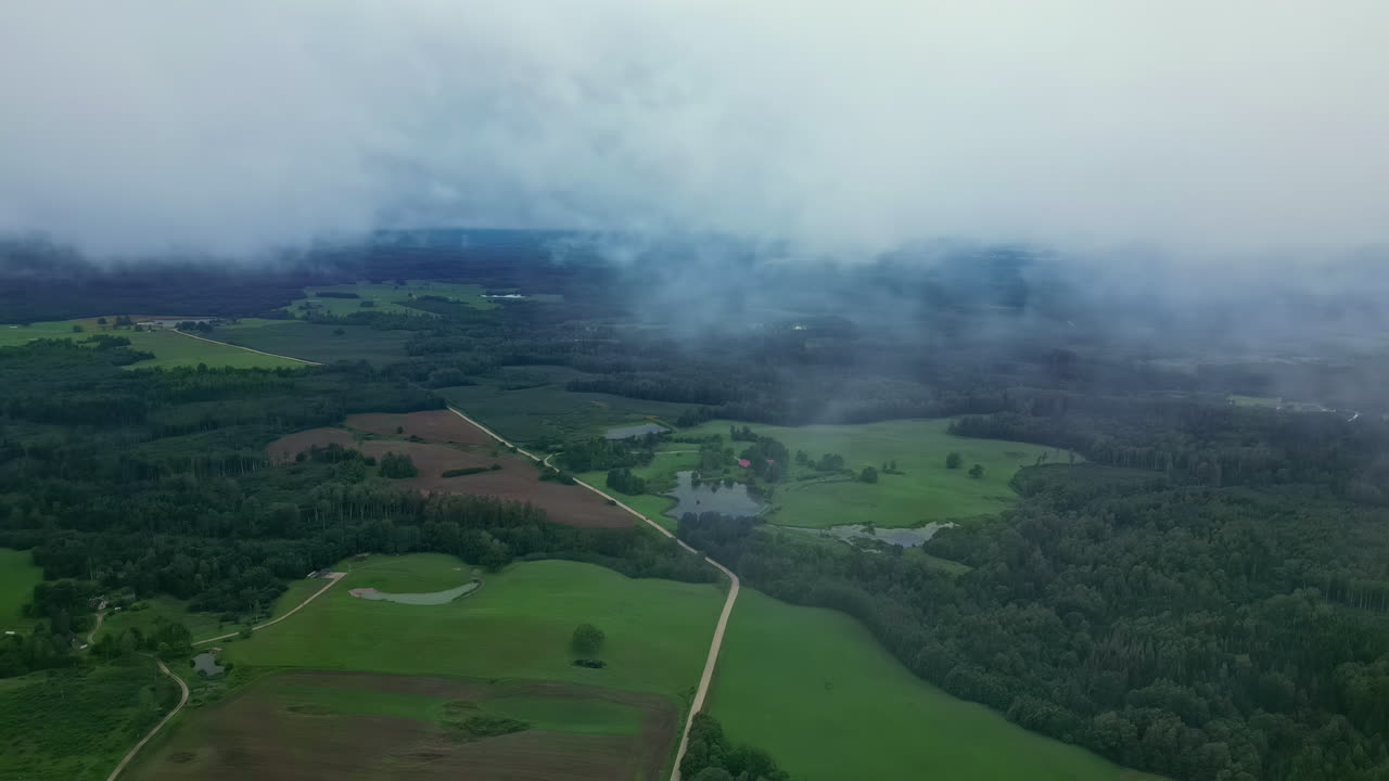 하늘 에 두꺼운 구름 이 있는 초록색 계곡 의 정적 한 항공기 드론 시각