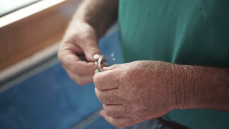 cerca del hombre preparando la línea de pesca con mosca