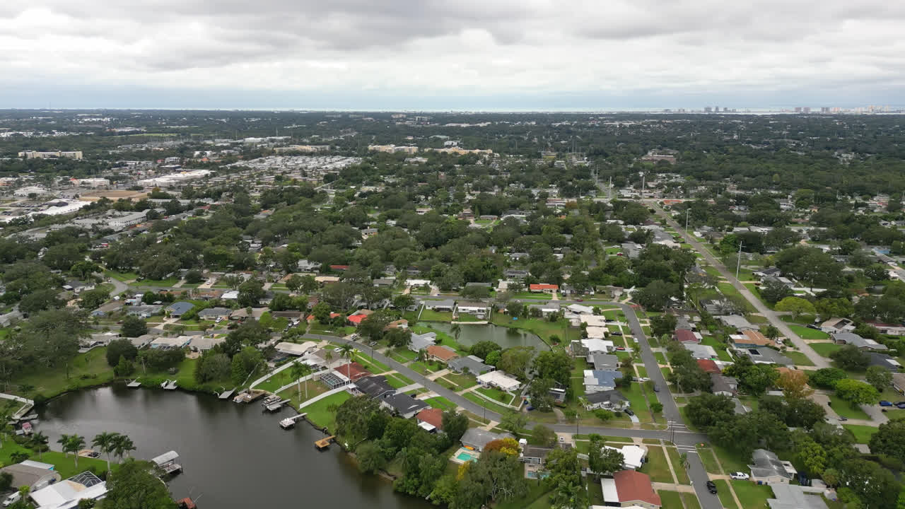 Aerial flyover of a suburban neighborhood built along canals and waterways, panoramic establishing