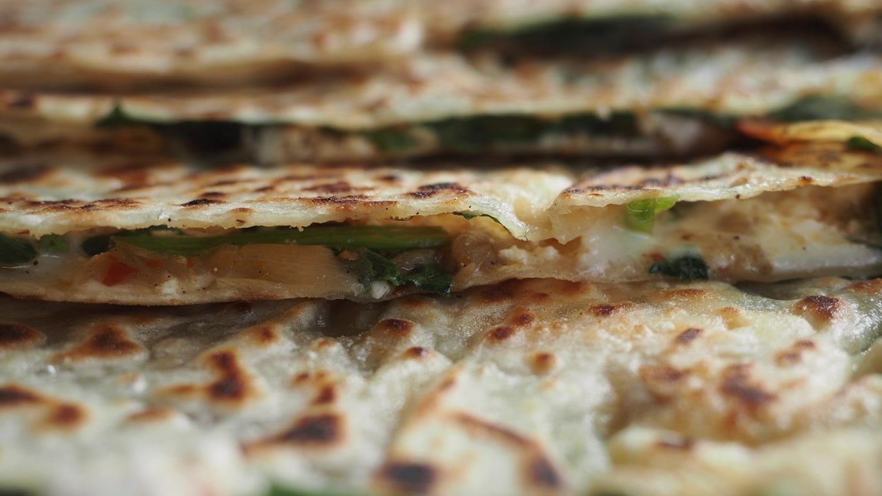 Close-up of Delicious Savory Flatbread with Cheese and Greens Filling