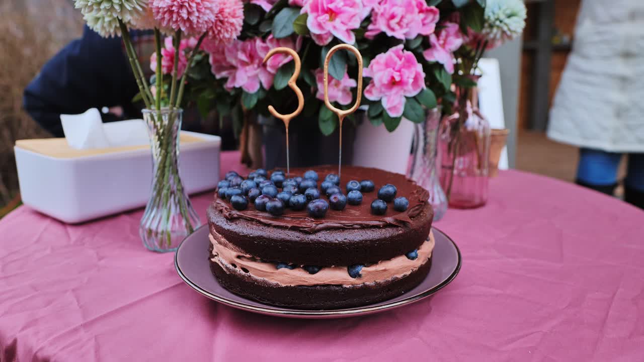 Layered chocolate cake with blueberries, sparkler in shape of 30, Latvia spring