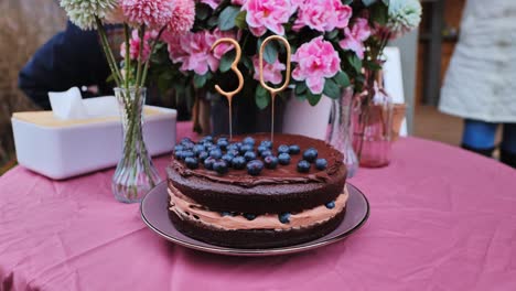 layered chocolate cake with blueberries, sparkler in shape of 30, latvia spring