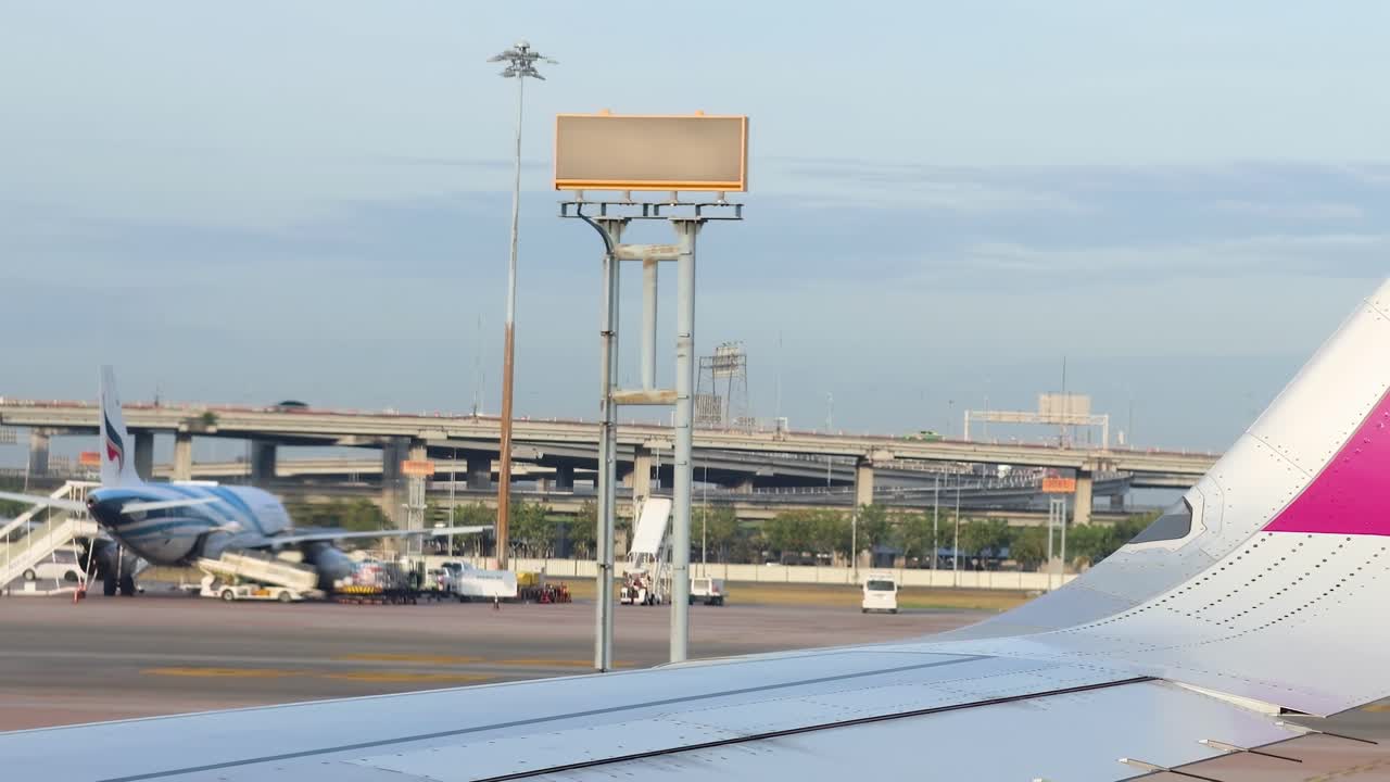 Airplane wing view with airport activity