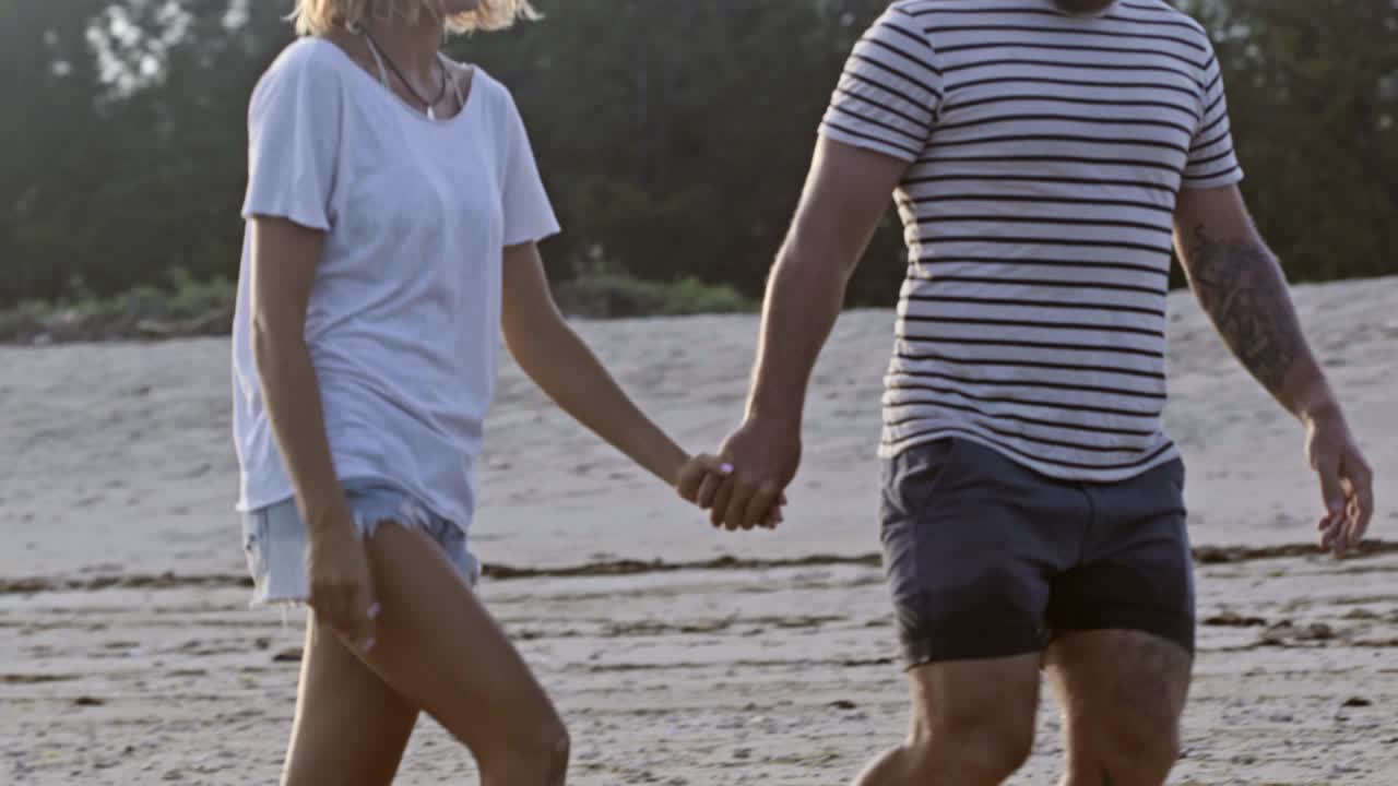 pareja caminando por la playa en vacaciones