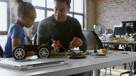 Father-and-daughter-using-soldering-iron-on-car-4k