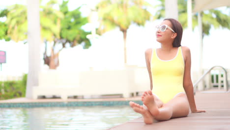 Mujer-Exótica-Feliz-Disfrutando-Del-Clima-Tropical-Caliente-En-Traje-De-Baño-Y-Gafas-De-Sol-De-Moda-Junto-A-La-Piscina-Del-Hotel-De-Lujo,-Fotograma-Completo