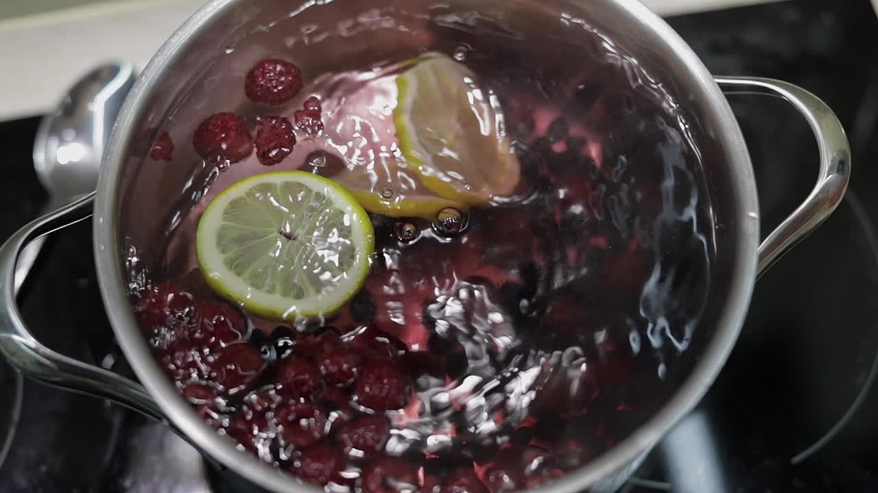 물과 열매와 함께 팬에 레몬 조각을 추가. 빨간, 검은 수박, 라즈베리