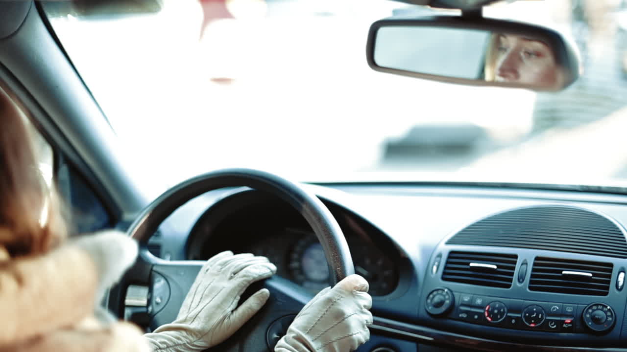 Woman driving a car in slow motion, hands on wheel