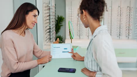 people in eye clinic looking at eyeglasses