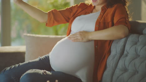 pregnant woman taking a selfie with baby shoes