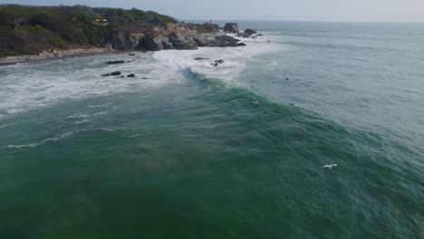 vista aérea sobre los surfistas montando olas en punta zicatela soleado océano pacífico costa de oaxaca