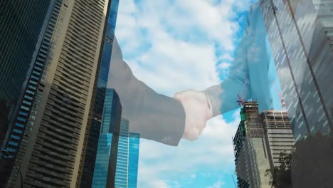 Mid-section-of-businessman-and-businesswoman-shaking-hands-against-tall-buildings-in-background