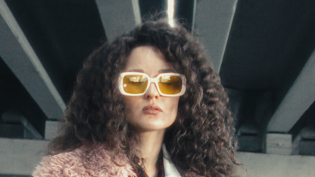Portrait of Stylish Girl in Yellow Sunglasses under Concrete Overpass