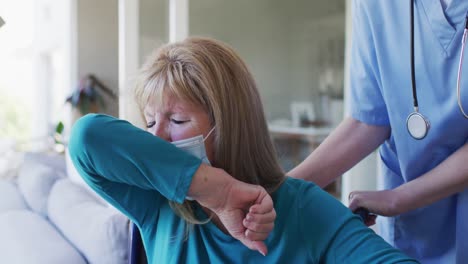 senior woman wearing face mask on wheelchair coughing on her elbow