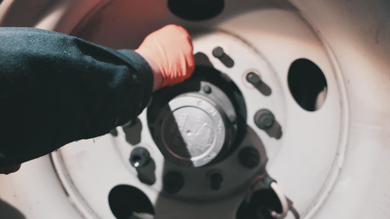 cerrar mecánico con guantes naranjas lazos tuercas pernos en un remolque