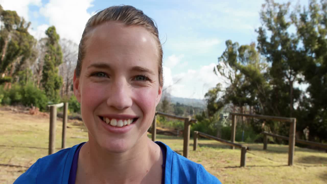 Smiling fit woman standing in park