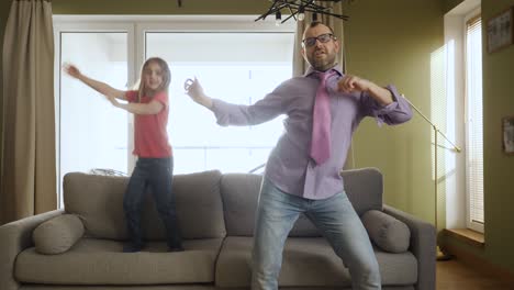 family enjoying dance, having fun party. joyful dad daughter dancing cheerful in living room.  happy father and daughter dancing at home living room, fun celebrating funny viral dance freedom weekend.