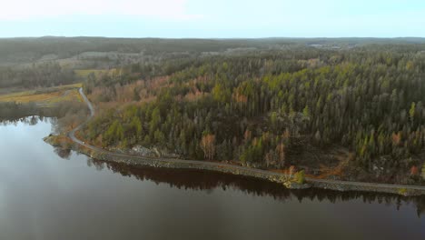 Road-with-beautiful-lake-on-one-side-and-tall-dense-greenery-on-other