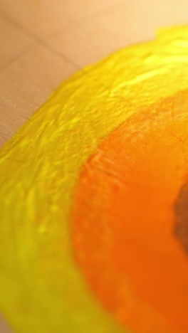 close-up of artist's brush applying vibrant yellow paint on canvas, showcasing the creative process and texture of the artwork in progress