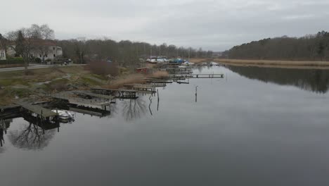 una vista escénica de pequeños puentes de madera sobre aguas tranquilas y barcos en el fondo de la ciudad naval de karlskrona, suecia