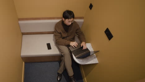 man working on laptop in private office space