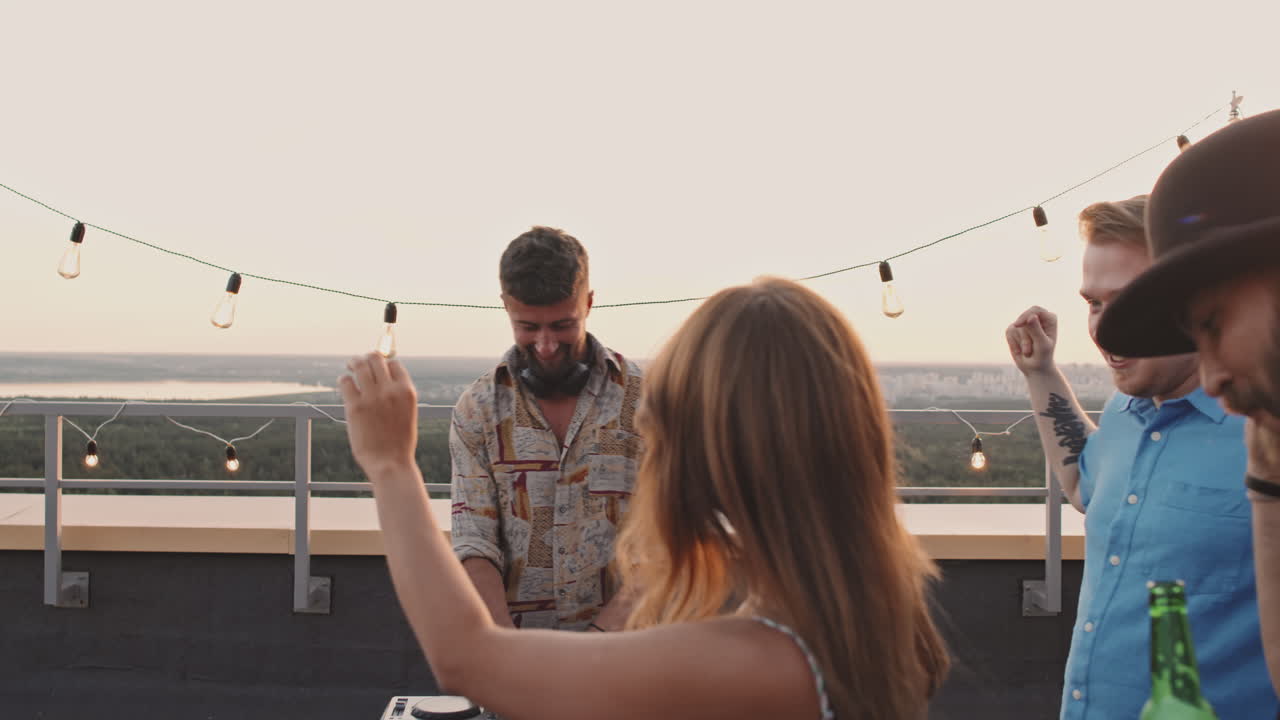 Man DJing and People Dancing on Rooftop Terrace