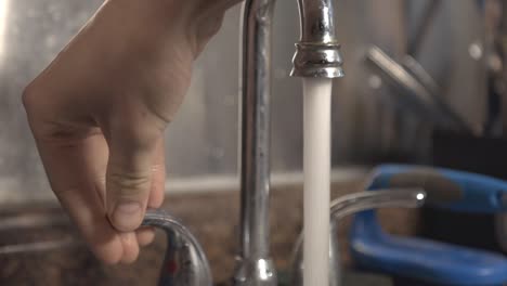 abrir el agua del grifo en el fregadero de la cocina