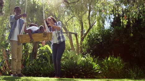 Little-boy-swinging-with-his-parents