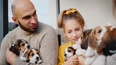 el padre y el niño están sentados en la puerta de su casa, jugando con cachorros