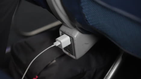 iphone charger plugged in on a long flight on an airplane - electricity, phone, battery life, charger, transportation