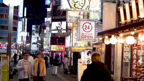 pedestrians walking through a neon-lit street