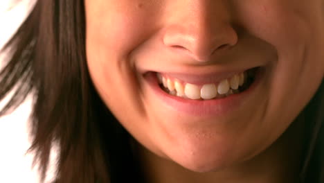 una morena feliz sonriendo sobre un fondo blanco