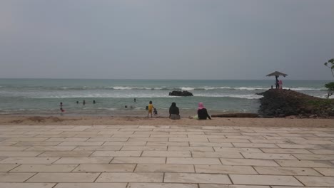 Ambiente-De-Playa-Durante-Las-Vacaciones,-Mucha-Gente-En-La-Playa,-Nadando-En-El-Mar-Por-La-Mañana