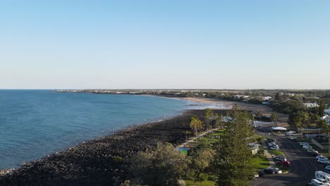 A high revealing drone video showing the coastline and open areas of the small town of Bargara located in the region of Bundaberg Queensland Australia