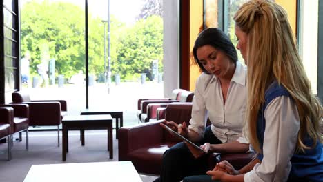 mujeres de negocios reflexivas que tienen una reunión usando una tableta