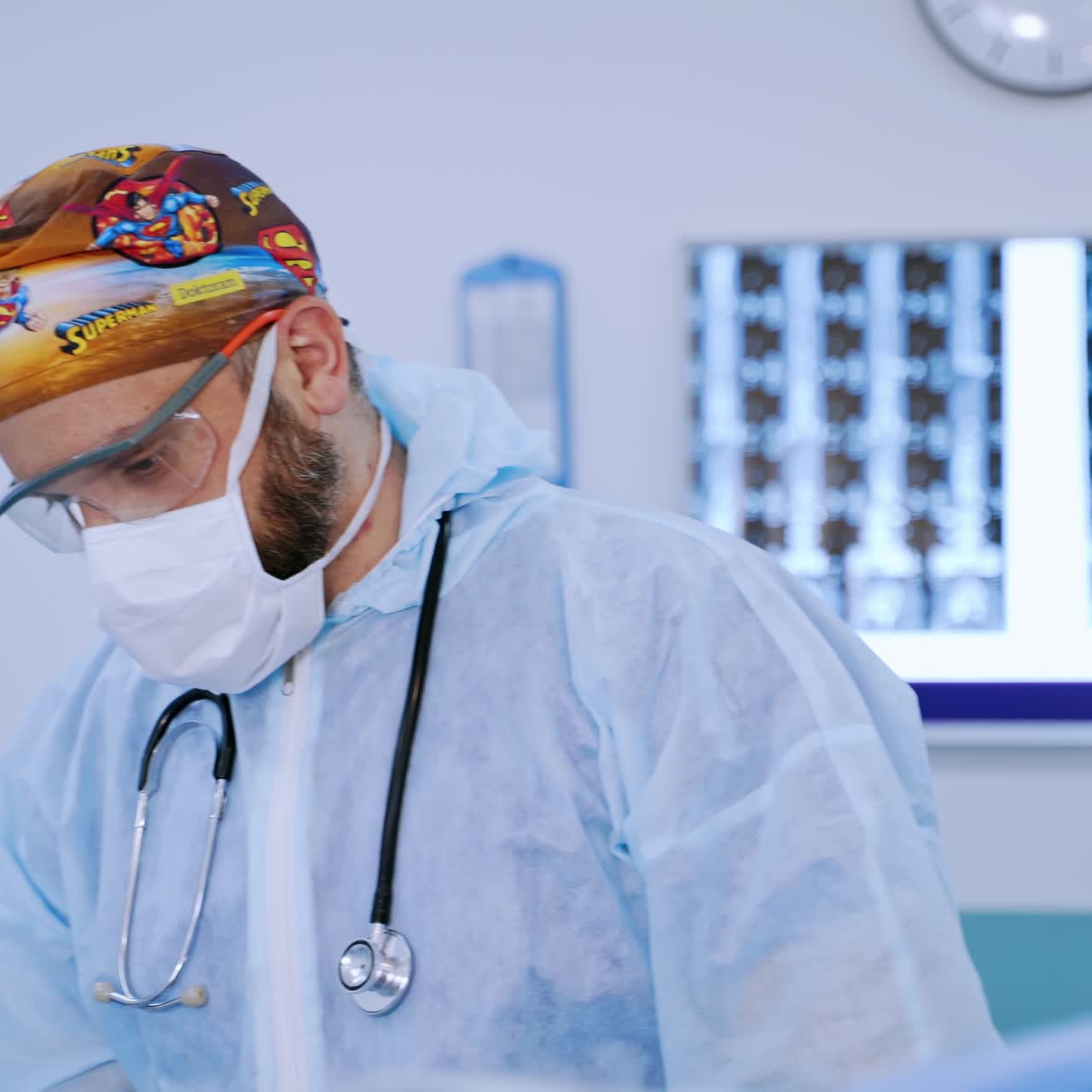 Professional doctor in mask and goggles in the hospital. Male surgeon in protective uniform working in the operating theater.