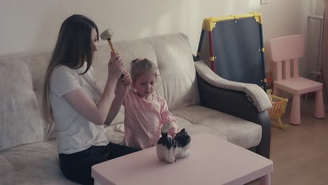 madre y un dulce hijo rompen una alcancía que está llena de monedas