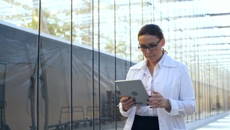 mujer de mediana edad caminando con una computadora