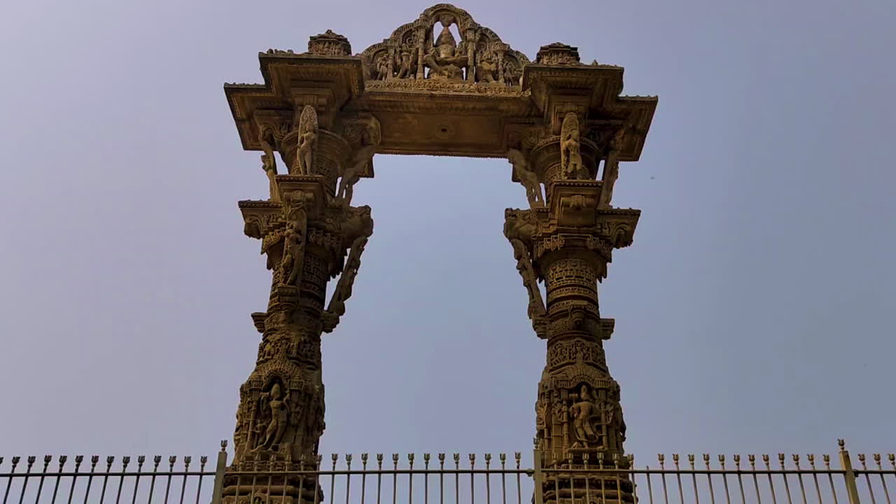 Kirti Toran stands tall with detailed stone carvings in Vadnagar, Gujarat, India. Ancient pillars frame blue sky showcasing historic Solanki era craftsmanship and heritage