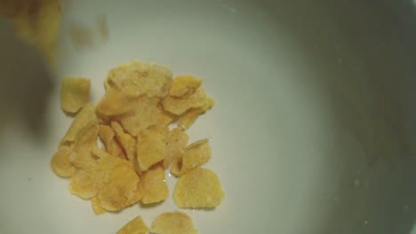 pouring cornflakes into a bowl