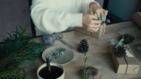 woman wrapping christmas gifts at a table