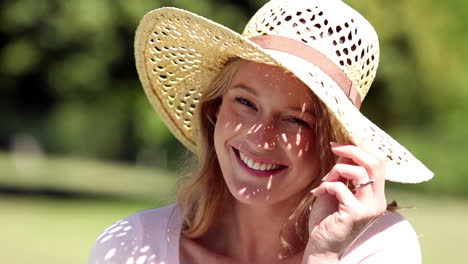 happy girl wearing a straw hat smiling at camera