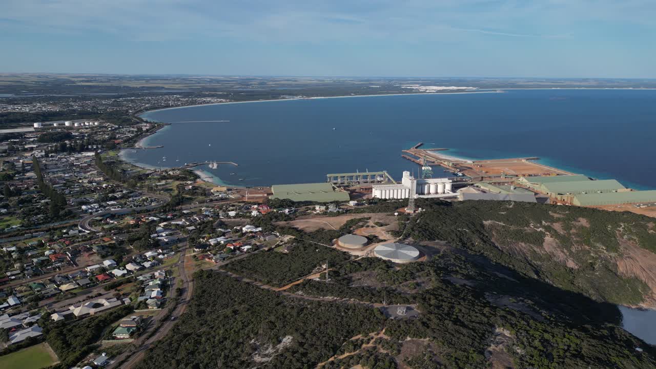 Aerial View of Coastal City with Industrial Port and Surrounding Landscape, wide angle dynamic