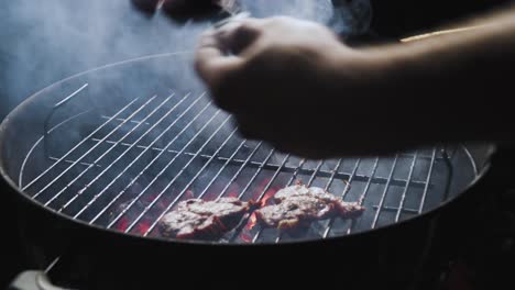 taking meat out of the grill isolated on black background